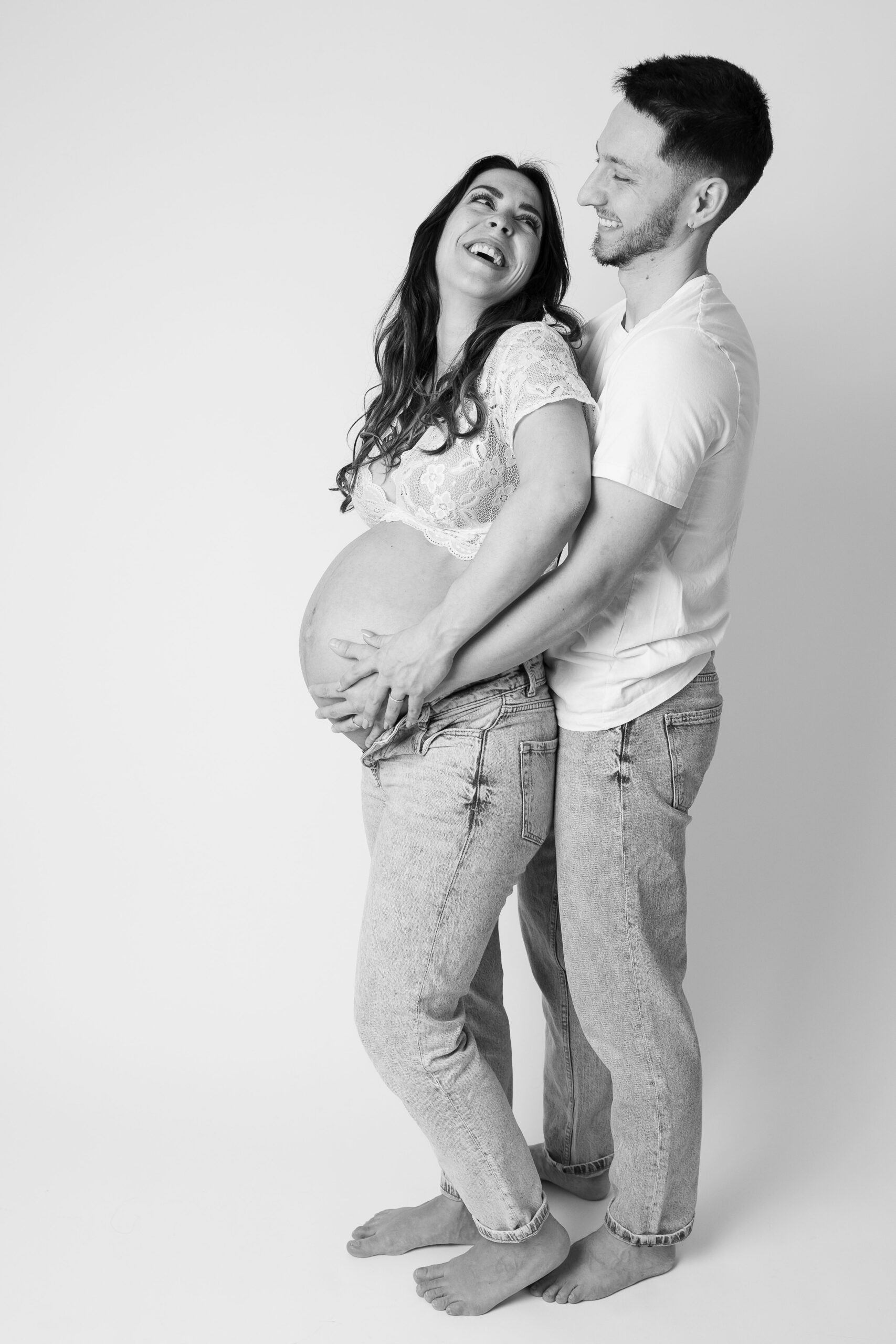 Séance photo grossesse réalisée en studio à Paris – couple complice en noir et blanc